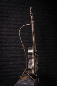 Spanish Ripper" reclaimed metal guitar sculpture by Paul Klaine, 56-inch tall steel artwork featuring chains, barbed wire, gears, and saw blade design, industrial contemporary art piece.