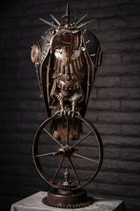 "Lurking Westward" reclaimed metal sculpture by Paul Klaine, vulture-like mechanical bird with spiked armor perched on a single steel wheel, industrial steampunk artwork.