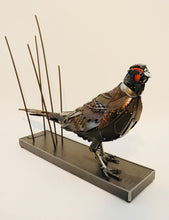 Load image into Gallery viewer, Losing Ground&quot; – Metal pheasant sculpture by artist David Groenjes, crafted from reclaimed steel and found objects, displayed in an outdoor natural setting.