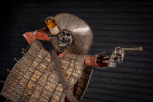 Load image into Gallery viewer, &quot;Shot for Shot&quot; reclaimed metal sculpture by Paul Klaine, 56-inch tall skeletal gunslinger with sombrero, tequila bottle, revolver, and industrial steel base with bell and candles.